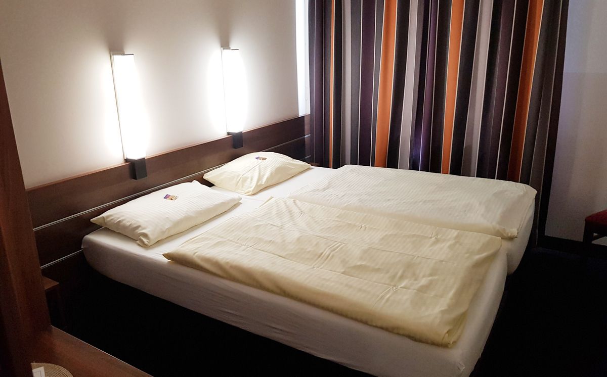 Bett in einem Hotelzimmer mit geschlossenem Vorhang